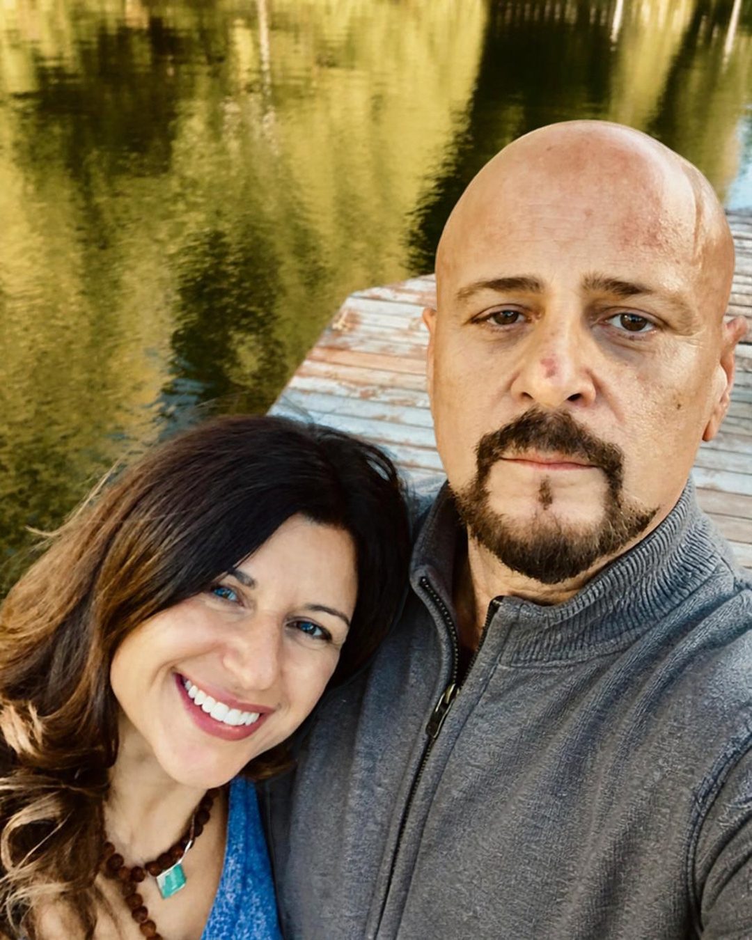 Brenda and Asim taking a selfie together on a dock by the water