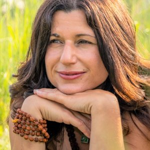 Brenda Farrugia smiling as she lies in the grass on the land